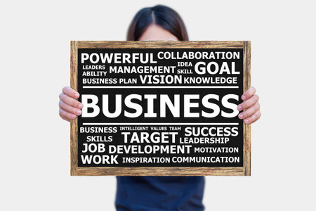 BUSINESS word on the blackboard wooden frame on hand asia woman with white background.business concept.の写真素材