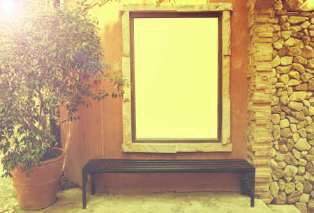 Vertical blank billboard with brick and bench.Vintage or retro tone.の写真素材