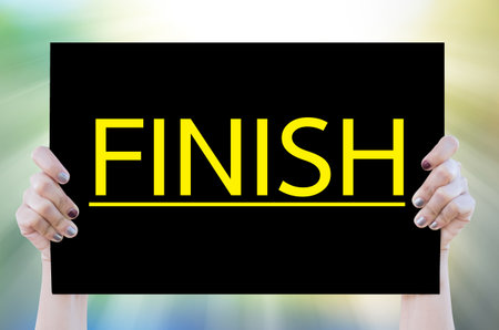 Hand woman holding blackboard with FINISH word on nature background.Business concept.の写真素材