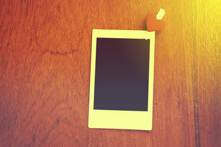 Blank instant photo and clippaper hanging on the wood.Designer concept.Vintage or retro tone.の写真素材