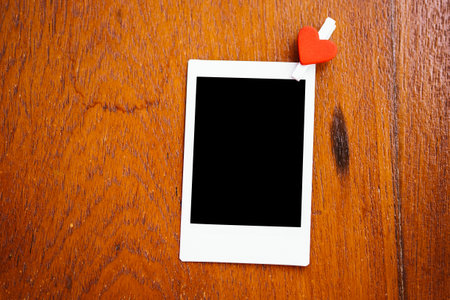 Blank instant photo and clippaper hanging on the wood.Designer concept.Vintage or retro tone.の写真素材