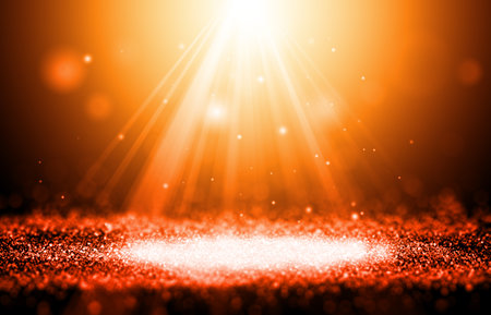 Gold and Orange color sparkle rays glitter lights with spotlight bokeh elegant show on stage abstract background. Dust sparks background.Spotlight backgroundの写真素材