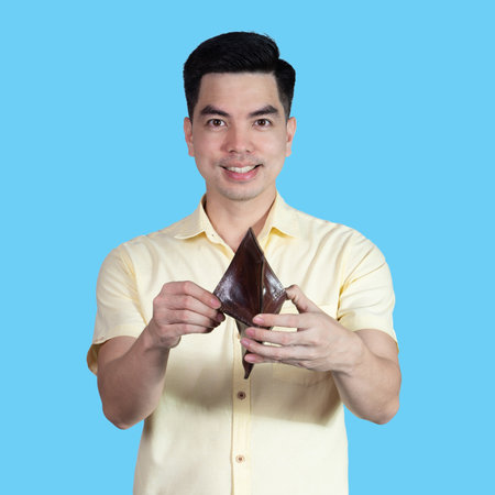 COVID-19 Coronavirus close up handsome young asian man wearing yellow shirt holding tablet and mask protection from covid 19 isolated on white background in studio. Asian man people.の写真素材