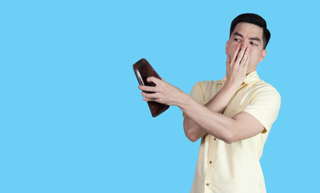 COVID-19 Coronavirus close up handsome young asian man wearing yellow shirt holding tablet and mask protection from covid 19 isolated on white background in studio. Asian man people.の写真素材