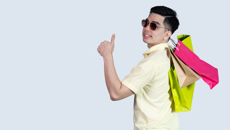 COVID-19 Coronavirus close up handsome young asian man wearing yellow shirt holding tablet and mask protection from covid 19 isolated on white background in studio. Asian man people.の写真素材
