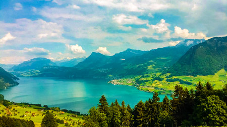 blue lake surrounded by mountains and forestの写真素材
