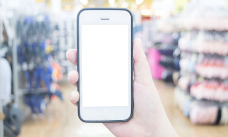 The young man's hand is holding a white screen phone, Mobile use phone concept.の写真素材