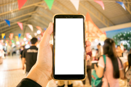 The young man's hand is holding a white screen phone, Mobile use phone conceptの写真素材