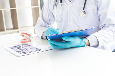 The dentist examining the teeth of the patient found that his teeth have improved.の写真素材