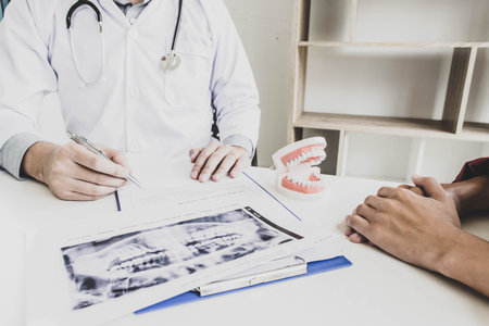 The dentist examining the teeth of the patient found that his teeth have improved.の写真素材