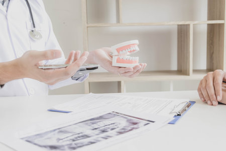 The dentist examining the teeth of the patient found that his teeth have improved.の写真素材