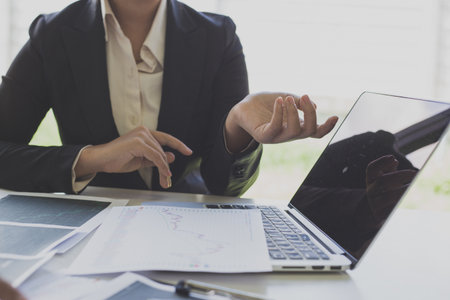 Businessmen are analyzing stock data, male company employees are discussing stock investment valuations, achieving business success.の写真素材