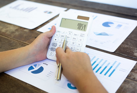 Analyze finances, financial accountants summarize income and expenses using a calculator to calculate, businessman workingの写真素材