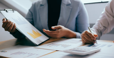 Meeting a team of businessmen, Executives and accountants meeting about the company's revenue graph in the office with laptops and calculators, Finance conceptの写真素材