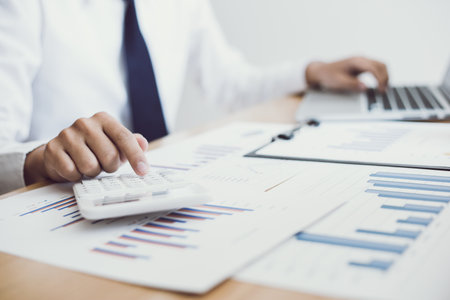 Business men analyze financial data for the company's revenue with graphs and calculators, accounting conceptの写真素材