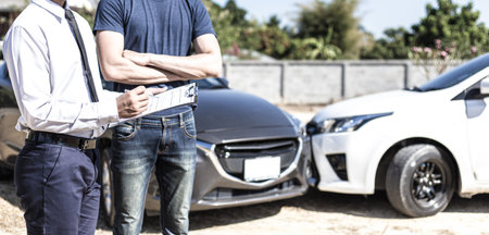 Insurance agents inspect for damage to cars that collide on the road to claim compensation from driving accidents, Insurance concept.の写真素材