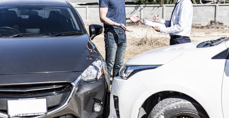 Insurance agents inspect for damage to cars that collide on the road to claim compensation from driving accidents, Insurance concept.の写真素材