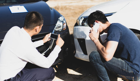 Insurance agents inspect for damage to cars that collide on the road to claim compensation from driving accidents, Insurance concept.の写真素材