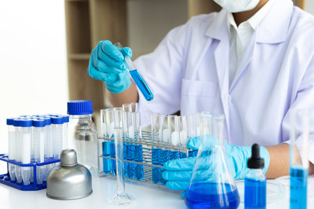 Scientists are carrying blue chemical test tubes to prepare for the determination of chemical composition and biological mass in a scientific laboratory, Scientists and research in the lab Concept.の写真素材