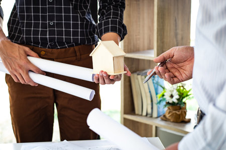 Engineers or architects are meeting a team to design the architectural structure in the design with blueprints and model buildings in working site, Technological structure and construction Concept.の写真素材