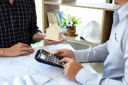 Engineers or architects are meeting a team to design the architectural structure in the design with blueprints and model buildings in working site, Technological structure and construction Concept.の写真素材