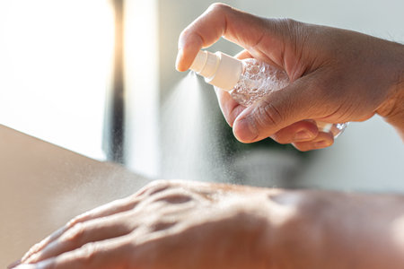 Young men use 70% alcohol spray to spray hands to get rid of bacteria and COVID-19 or CORONA viruses that destroy the respiratory system, COVID-19 virus protection concept.の写真素材