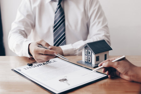 Real estate broker agents advise clients to make a decision to buy a house with insurance. Negotiating purchase-sale and investment planning concept.の写真素材
