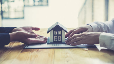 Real estate broker has given the house to customers who bought the house with insurance, Negotiating purchase-sale and investment planning concept.の写真素材