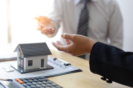 Real estate broker agents advise clients to make a decision to buy a house with insurance. Negotiating purchase-sale and investment planning concept.の写真素材