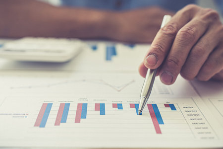 Businessmen analyze market data and calculate the cost of buying-selling products for a client's...