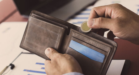 Businessman with a brown bag and a coin, Saving money and spending using cash concept.