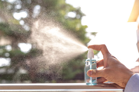 Young men use 70% alcohol spray to eliminate bacteria and viruses CORONA Or influenza COVID-19,...