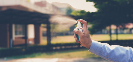 Young men use 70% alcohol spray to eliminate bacteria and viruses CORONA Or influenza COVID-19, Infection control and prevention of the spread of the disease CORONA or COVID-19 concept.の写真素材