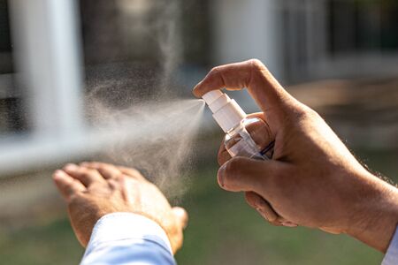 Young men use 70% alcohol spray to eliminate bacteria and viruses CORONA Or influenza COVID-19, Infection control and prevention of the spread of the disease CORONA or COVID-19 concept.の写真素材