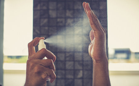 Man uses a spray of alcohol to get rid of bacteria and viruses, Inhibition and prevention of Covid-19 virus infection using 70 percent alcohol, protect virus concept.の写真素材