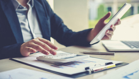 Accounting businessmen are calculating income-expenditure and analyzing real estate investment data, Dedicated to the progress and growth of the company, Financial and tax systems concept.の写真素材