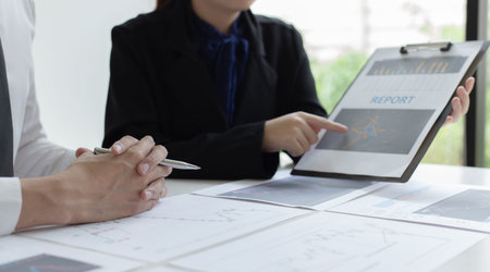 Accountants and financiers are brainstorming the analysis of revenue performance with stock graphs...