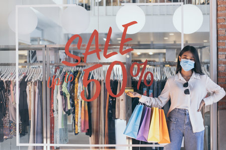 Young Asian women happily carry colorful shopping bags to shop in the mall or shopping center, Sale...