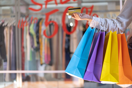 Young women carry colorful shopping and use their credit card to shop at the mall, Consumerism of Asian people who are happy to buy products.の写真素材