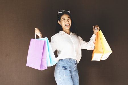 Young Asian women happily carry colorful shopping bags to shop in the mall or shopping center, Sale day, Happy shopping concept.の写真素材
