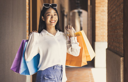 Young Asian women happily carry colorful shopping bags to shop in the mall or shopping center, Sale day, Happy shopping concept.の写真素材