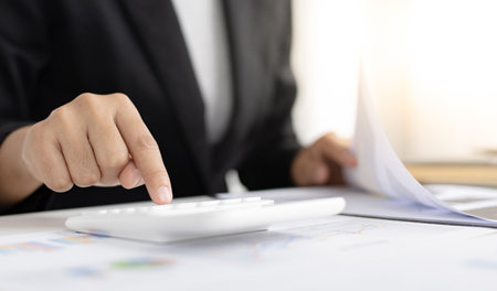Accounting businessmen are calculating income-expenditure and analyzing real estate investment data, Dedicated to the progress and growth of the company, Financial and tax systems concept.の写真素材