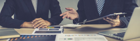 Meeting a team of businessmen, Executives and accountants meeting about the company's revenue graph in the office with laptops and calculators, Finance concept.の写真素材