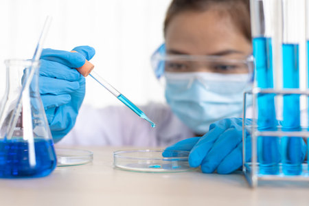 Scientists are carrying blue chemical test tubes to prepare for the determination of chemical...