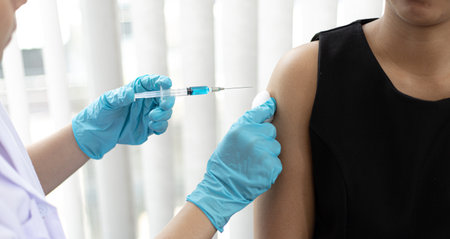 Doctor is vaccinating women with antibiotics or new antibodies to prevent the spread of the virus, Vaccination against communicable diseases conceptの写真素材