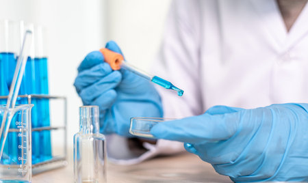 Scientists are carrying blue chemical test tubes to prepare for the determination of chemical...