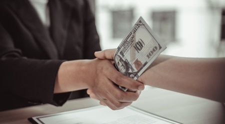 Businessmen give dollars to bribe employees in signing contracts to buy illegal land and real estate, Business fraud and social injustice, corruption and bribery concept.の写真素材