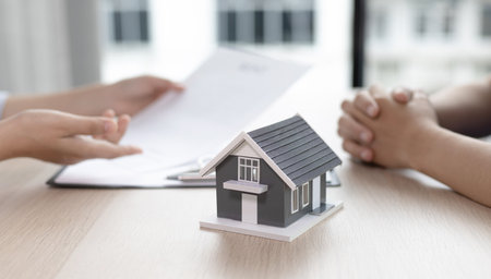 Real estate agent or sales manager has proposed terms and conditions to customers who sign house purchase agreements with insurance, Agreement to sign the purchase contract concept.の写真素材