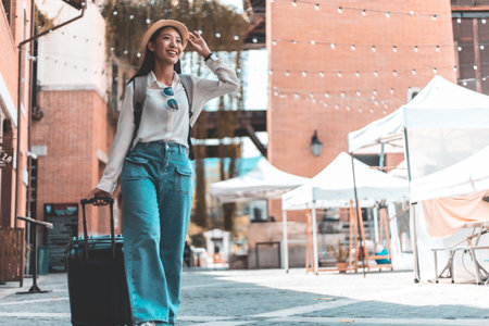 Asian woman beaming carrying a suitcase black to travel on vacation, Trolley bag, Long weekend travel, Love the trip, Tourism festival concept.の写真素材
