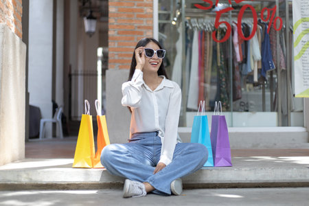 Young Asian women happily carry colorful shopping bags to shop in the mall or shopping center, Sale day, Happy shopping concept.の写真素材